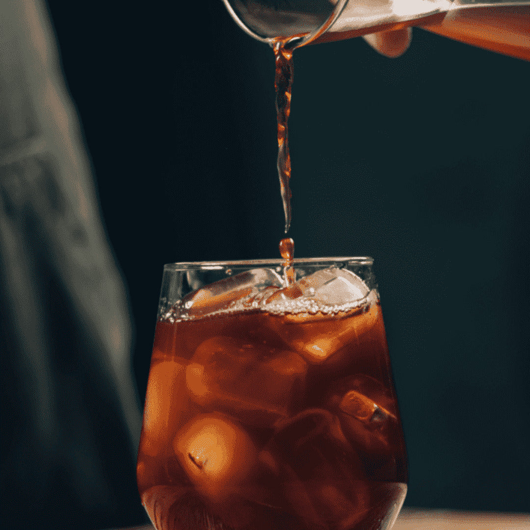 café gelado sendo servido em copo de vidro