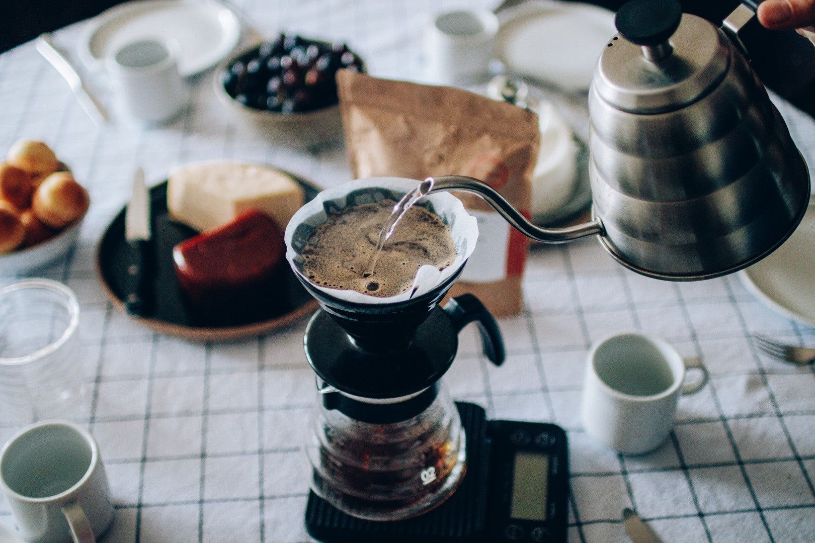 café sendo preparado em v60 em cima de uma mesa de café da manhã