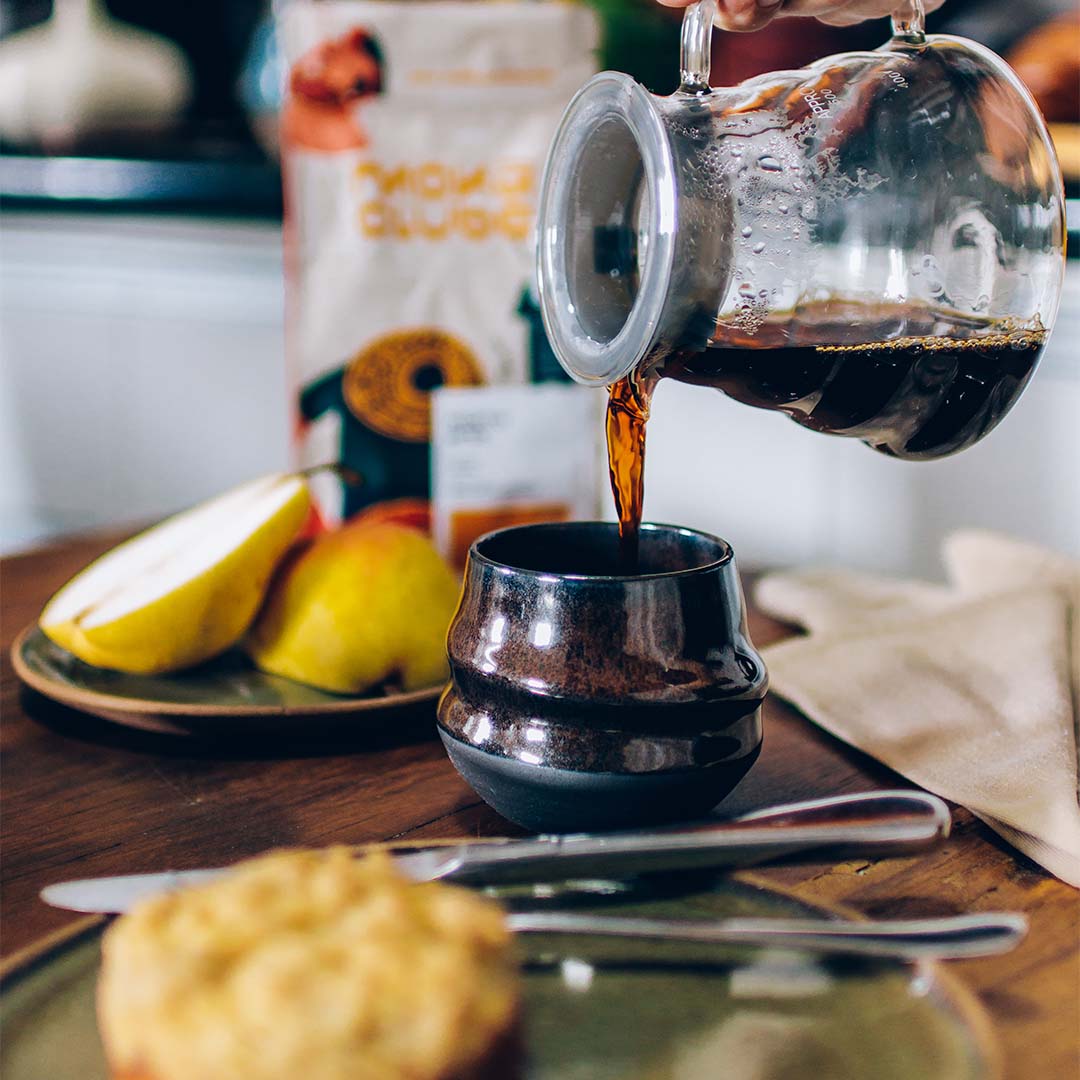 café sendo servido sem copo de cerâmica em mesa de café da manhã