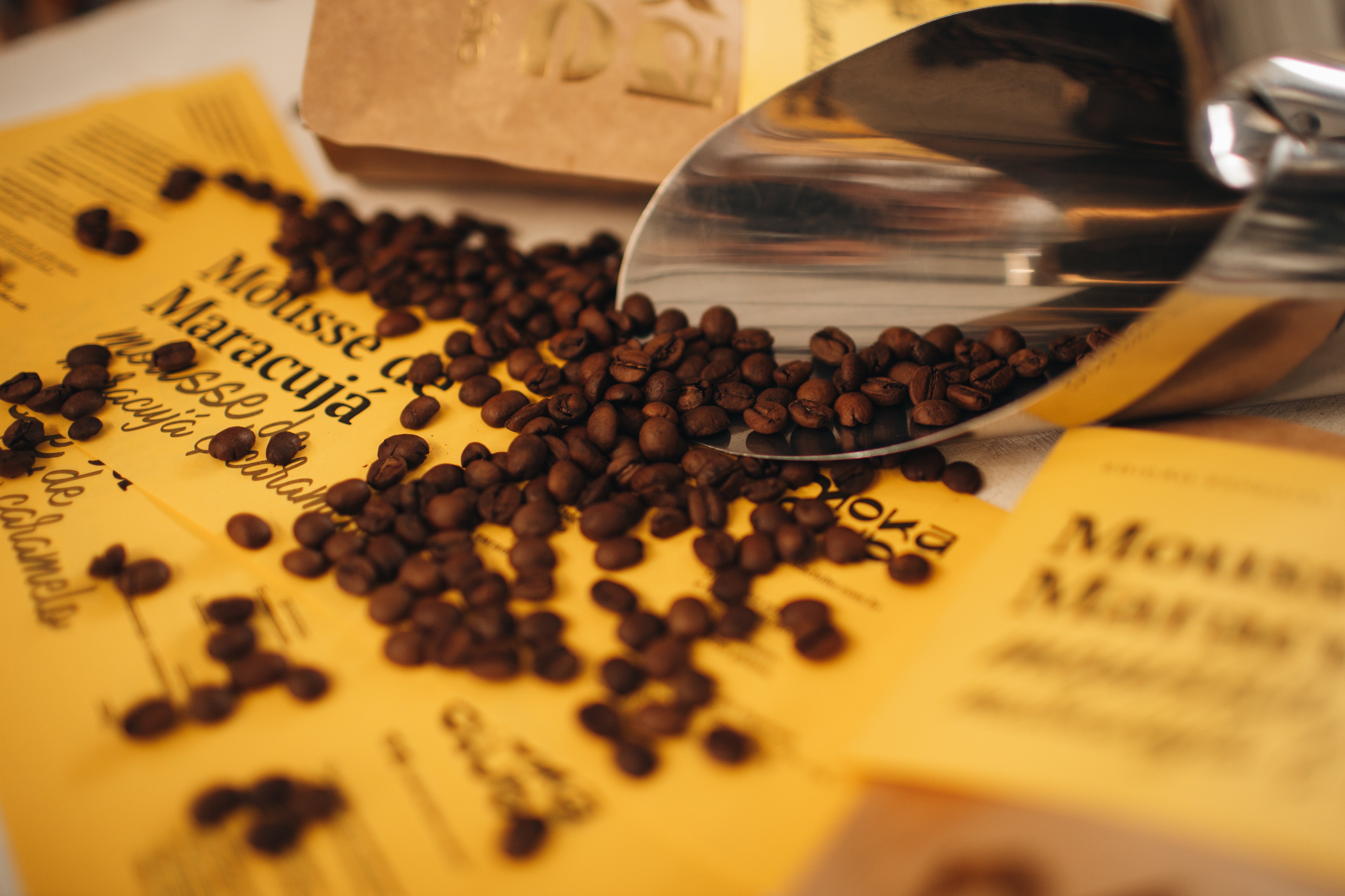 Grãos de café e copo medidor em cima de papel amarelo