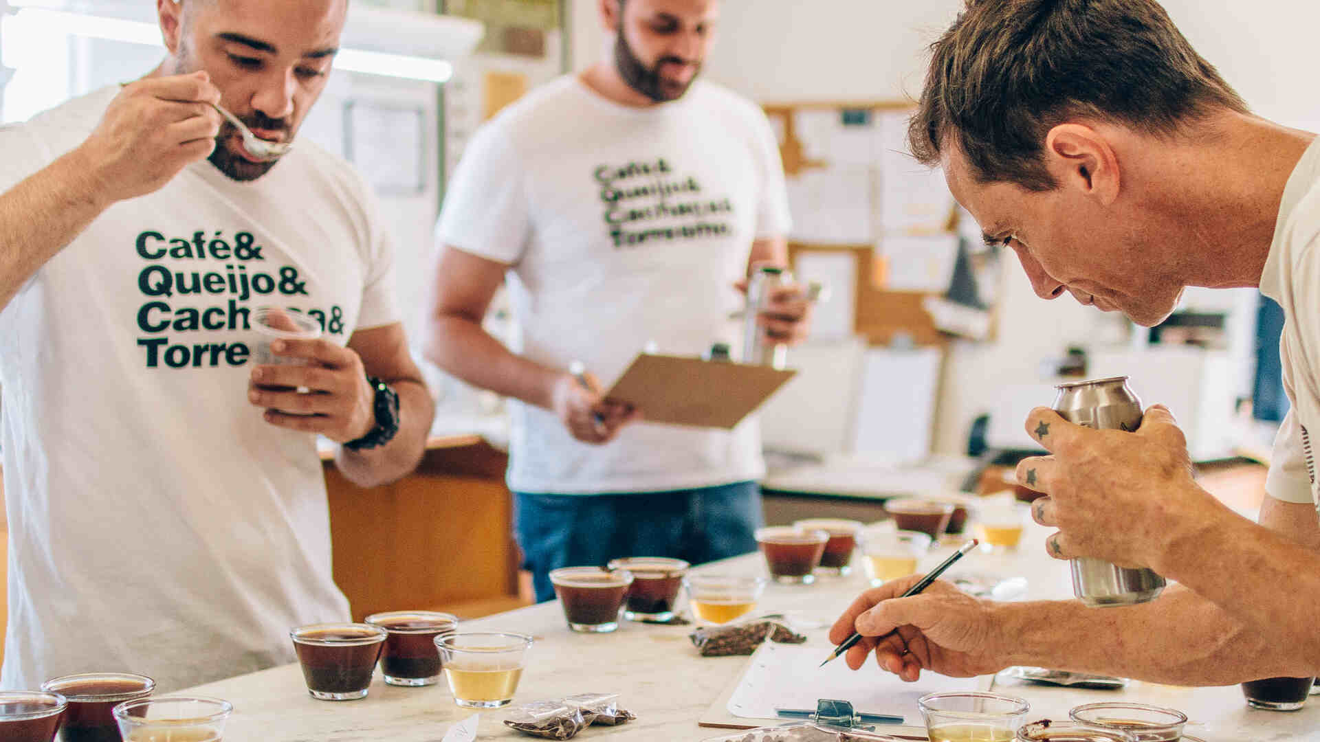 Pessoas ao redor de mesa de análise sensorial de cafés