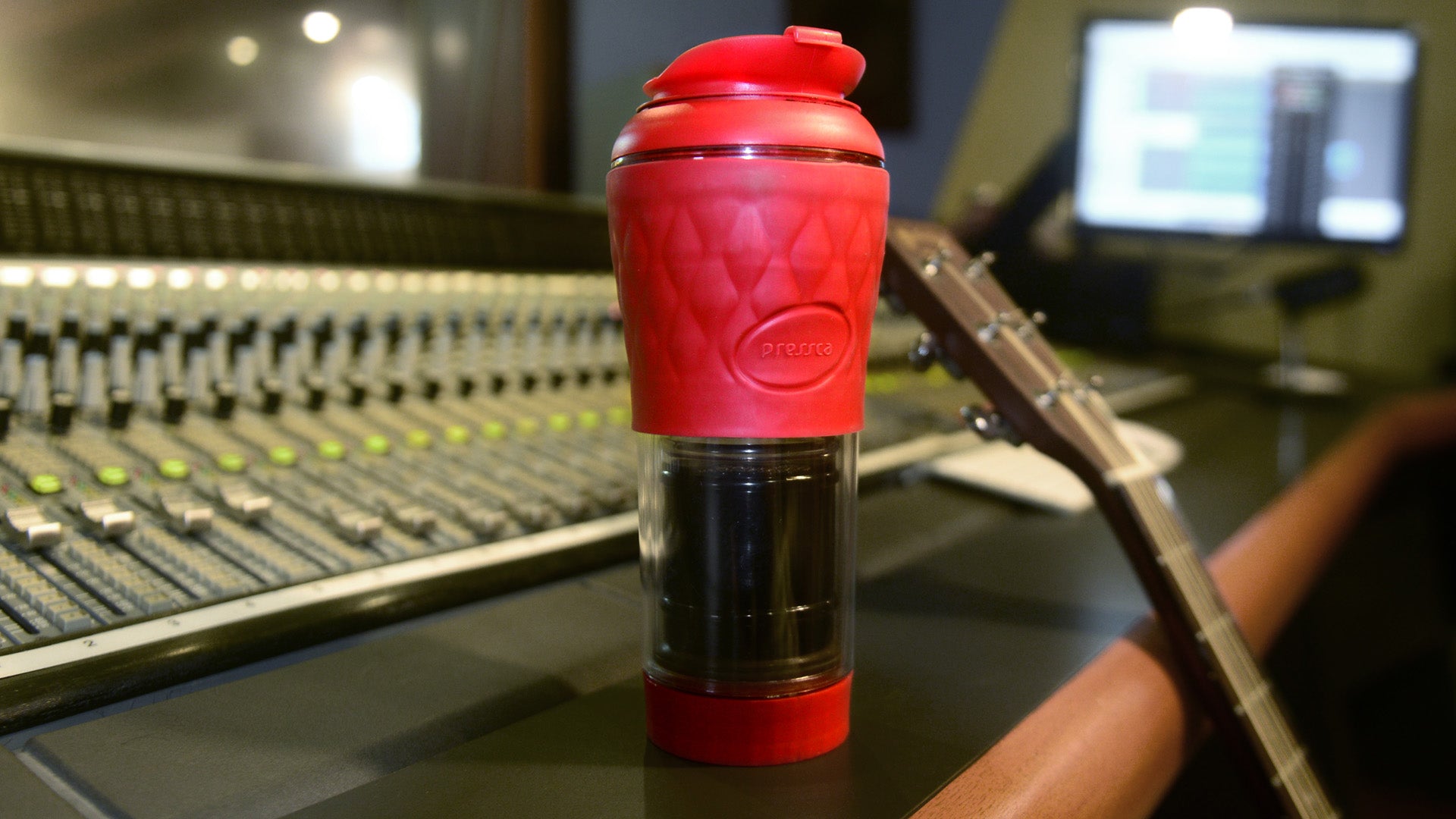 Pressca vermelha em estúdio de música ao lado de um violão