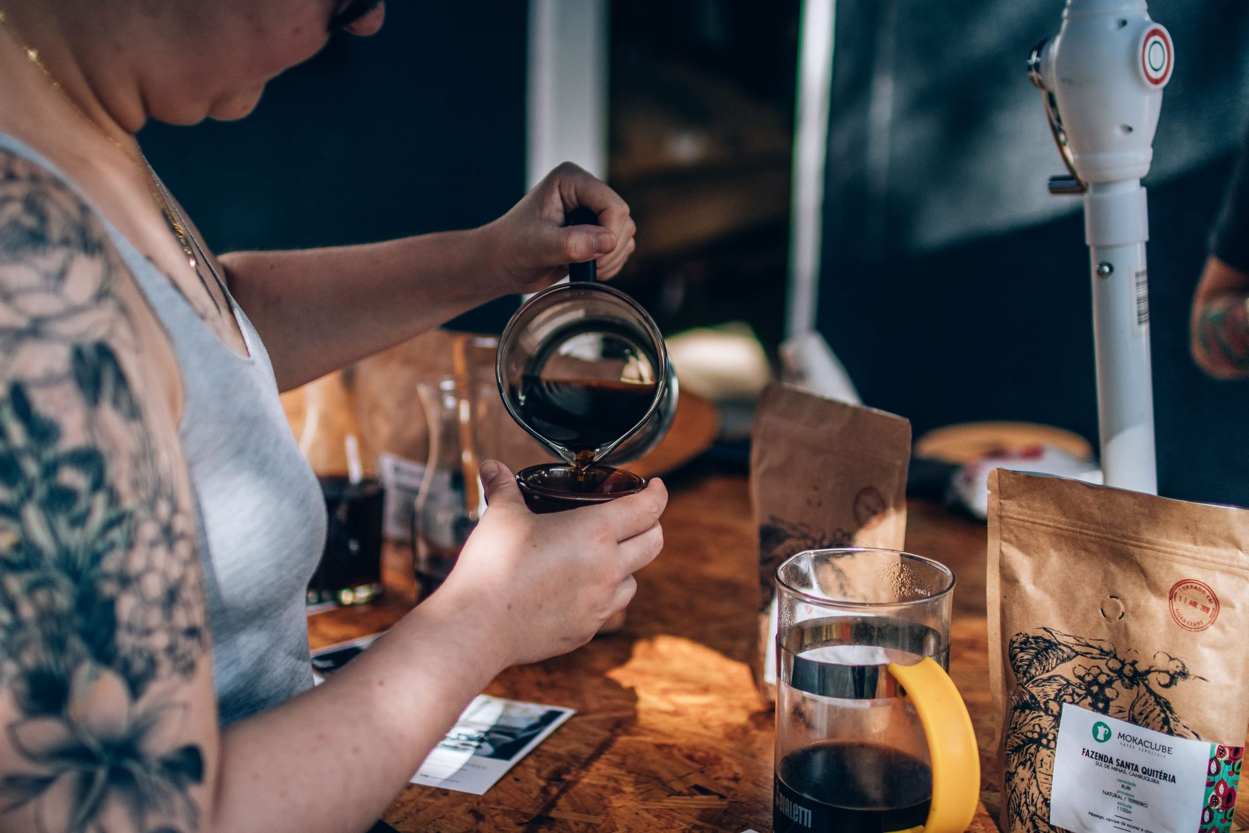 Mulher servindo café especial na xícara.