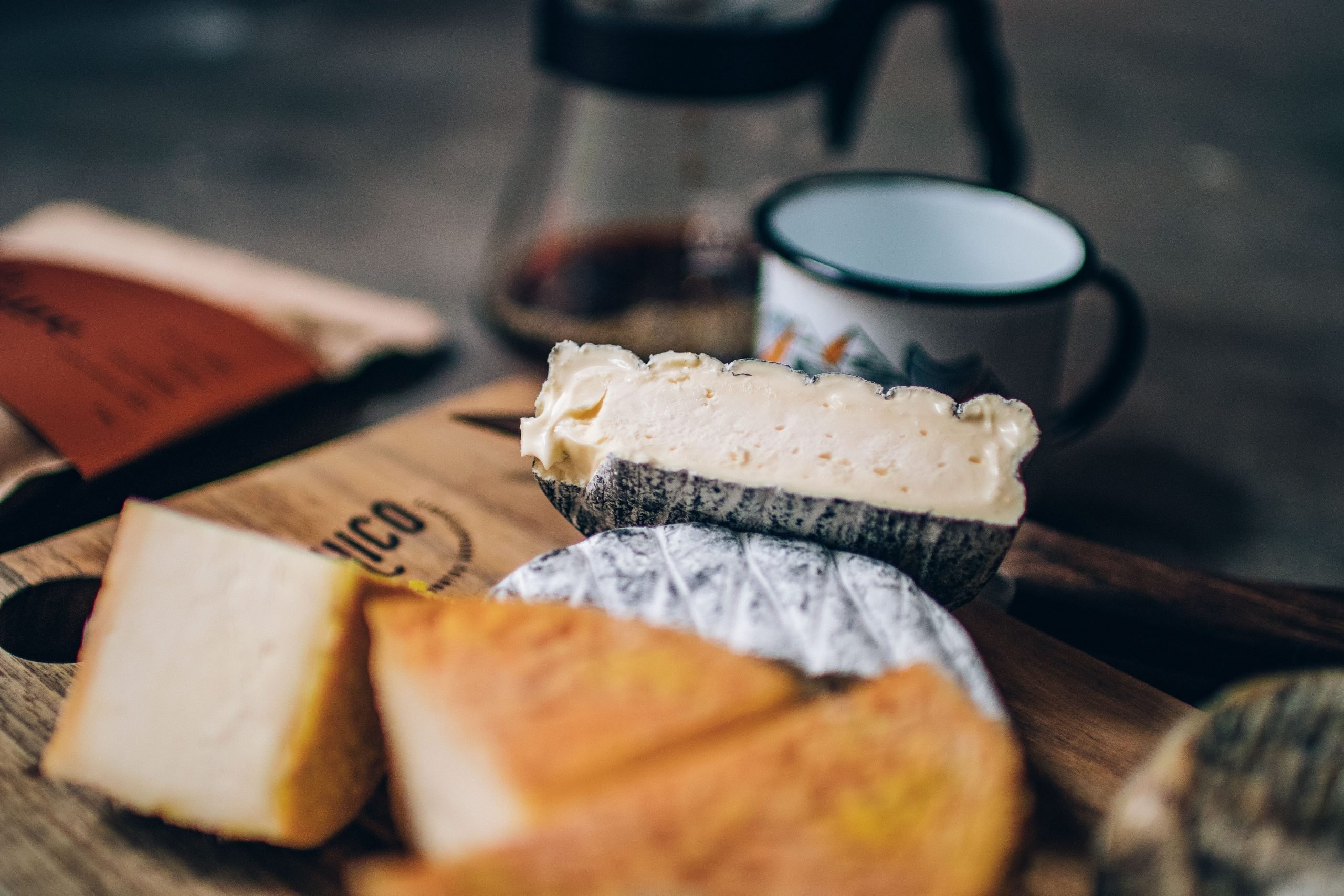 Queijos, alimentos influenciados pelo terroir como o café. disposto em uma tábua.