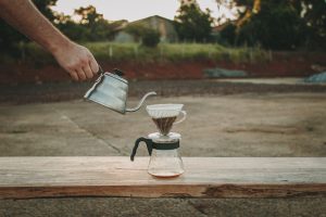 Pessoa utilizando equipamentos para fazer café para passar a bebida.