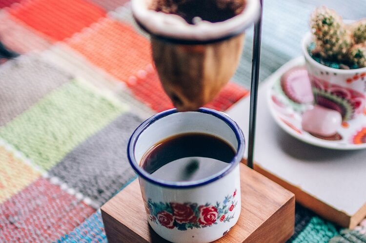 Coador de café de pano com xícara embaixo.