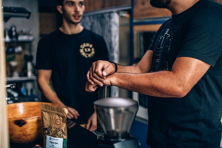 Dois homens conversando e fazendo café