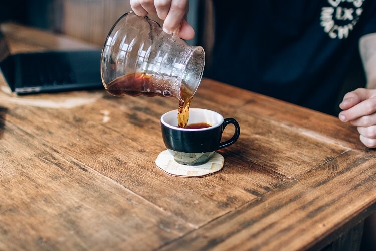 Homem servindo café em uma xícara