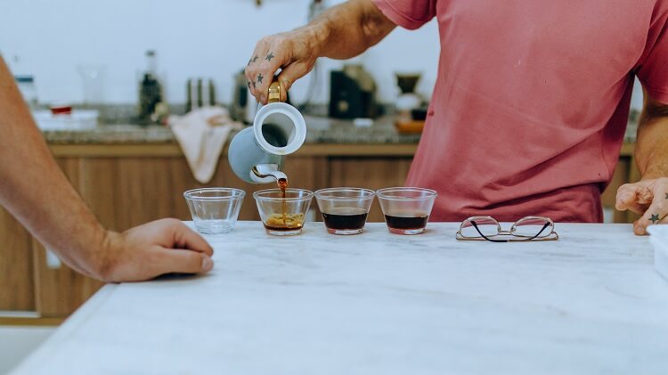 Homem servindo café e analisando